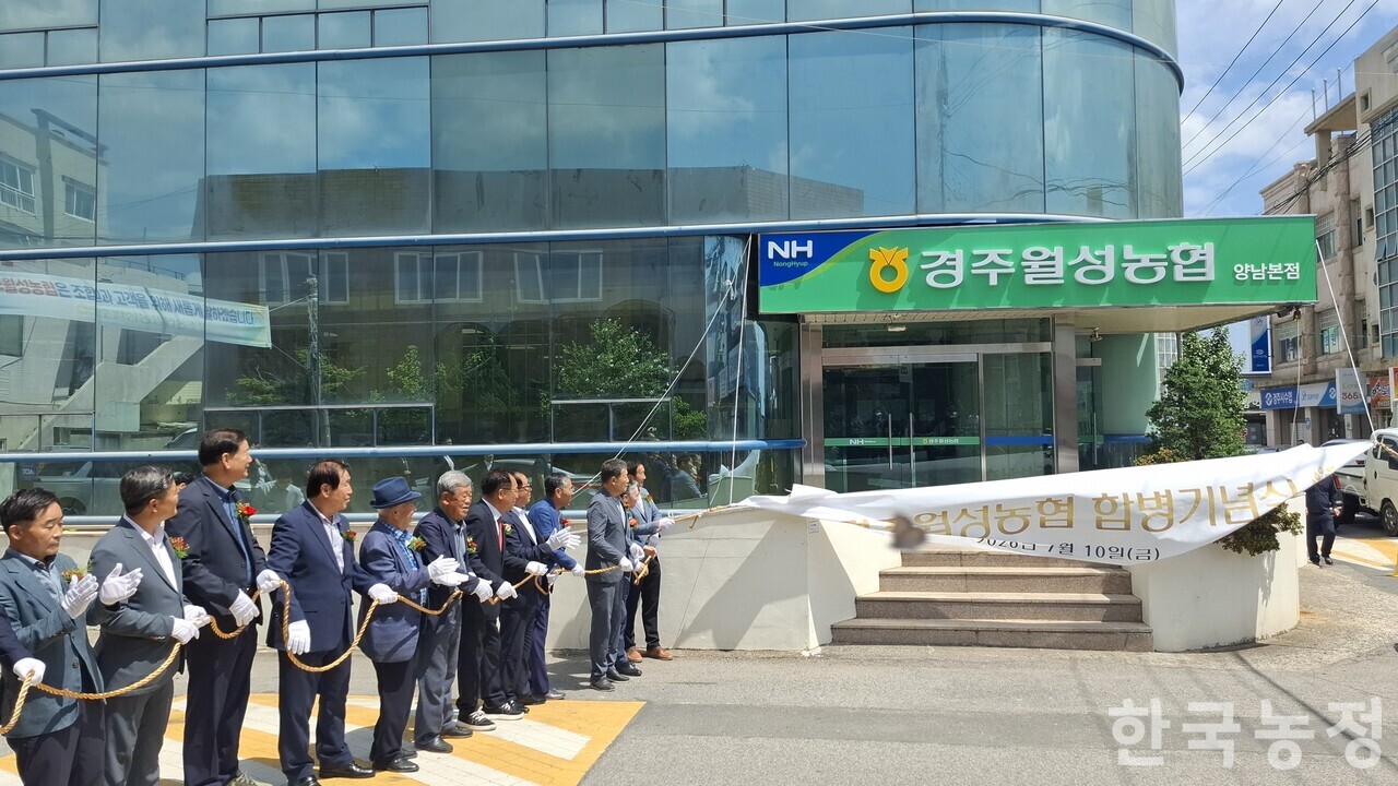 지난 10일 경북 경주시 양남면 경주월성농협 합병기념식 중 백민석 경주월성농협 조합장 등 행사에 참석한 지역농협 조합장들이 현수막을 벗겨내 경주월성농협의 새 현판을 드러내 보이고 있다. 경주월성농협은 옛 양남농협·동경주농협 간 합병으로 출범했다.