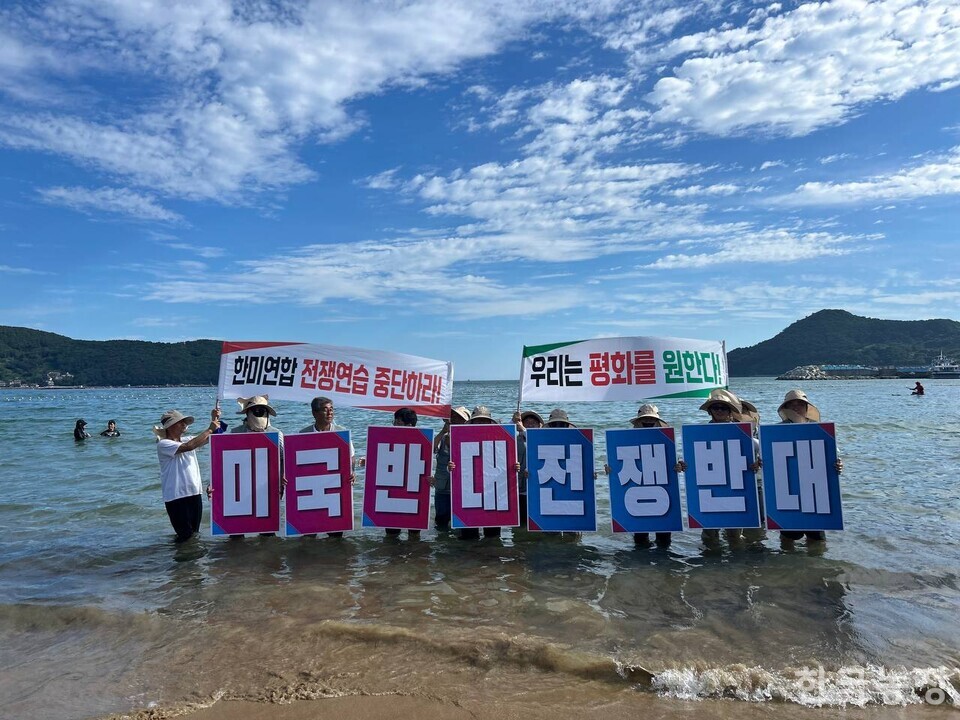 지난 25일 경남 거제 와현해수욕장에서 2025 경남농민자주평화실천단이 홍보 실천활동을 펼치고 있다.